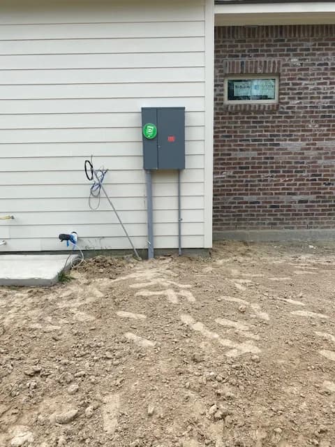 Close-up of the 200A house disconnect mounted on white siding next to brick exterior