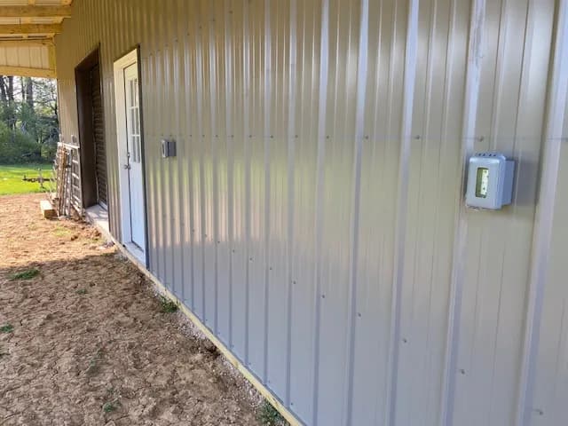 Side wall of the shop with motion-sensor light box mounted next to entry door